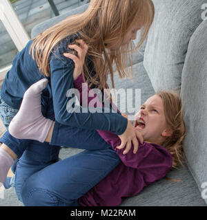 A 7- and a 9-year-old girl scream at each other and beat each other Stock Photo