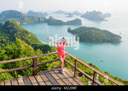 Woman tourist standing posing on the podium is peak view point of Ko Wua Ta Lap and beautiful nature landscape of island and sea in Mu Ko Ang Thong Na Stock Photo