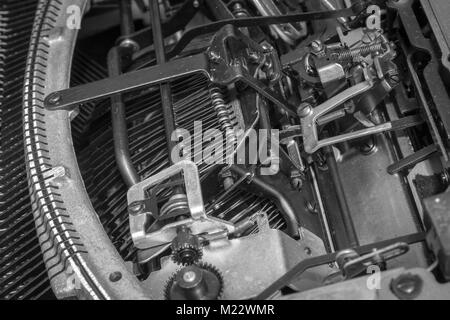 A view of an antique manual typewriter mechanism from underneath a portable typewriter built in the 1940s. Stock Photo