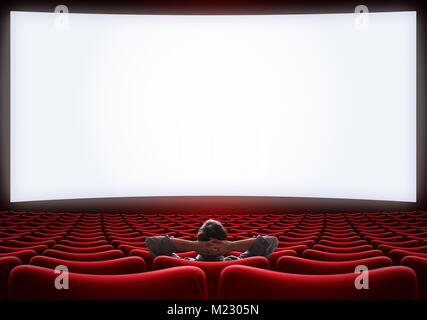 empty cinema hall with lonely man sitting in center Stock Photo
