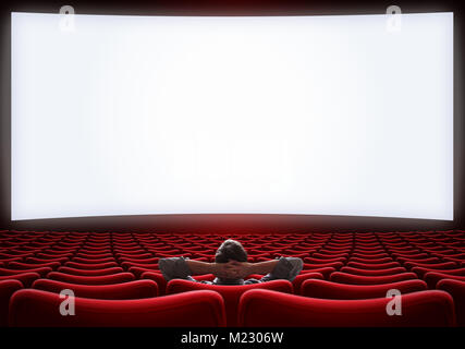 empty cinema hall with lonely man sitting in center Stock Photo