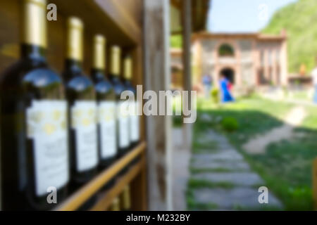 Five wine bottles on a shelf, blurred background. in the background is seen the building Stock Photo