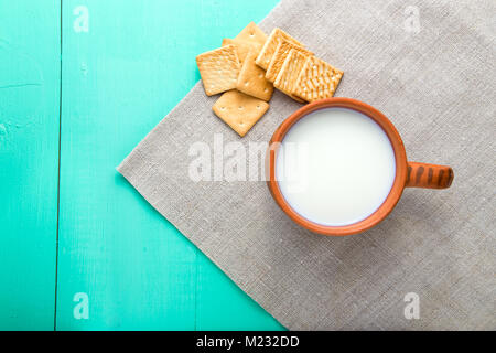 healthy breakfast cup of milk and crackers on a wooden blue surface on a linen napkin, top view Stock Photo