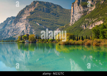 Spectacular Toblino lake with high mountains and medieval Castle Toblino in background near Garda lake, Trentino Alto Adige, Italy, Europe Stock Photo