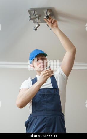 Handsome male electrician changing the light bulb. Stock Photo