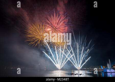 Bright and colorful fireworks against a black night sky.Fireworks for new year. Beautiful colorful fireworks display on the urban lake for celebration Stock Photo