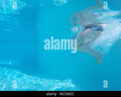 Underwater shot of unrecognizable person's legs in swimming pool.Clear blue water Stock Photo