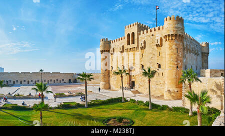 ALEXANDRIA, EGYPT - DECEMBER 17, 2017:  Panorama of Qaitbay citadel's courtyard with garden, castle and parade ground, surrounded by massive walls, on Stock Photo