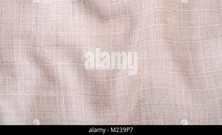 Decorative texture from wavy fabric. Stylish beige background from creased textile with copy space. Stock Photo