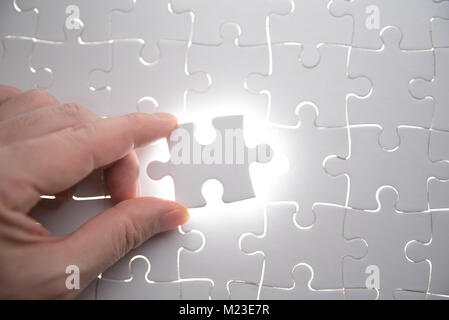 jigsaw puzzle piece with light glow, business concept for completing the final puzzle piece Stock Photo