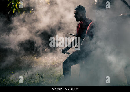 AYUTTHAYA, THAILAND - DECEMBER 17: Two ancient swordmen  be ambush alert in the smoke of war fire make more shadow and Silhouette and prepare for atta Stock Photo