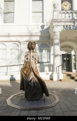 A bronze sculpture of Jane Austen outside the old town hall, now housing the Willis museum, in Basingstoke town centre, Hampshire, UK. Stock Photo