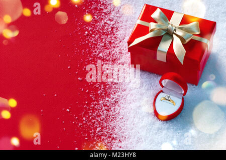 Valentine gift and jewellery box on snow and red background. St. Valentines Day concept Stock Photo