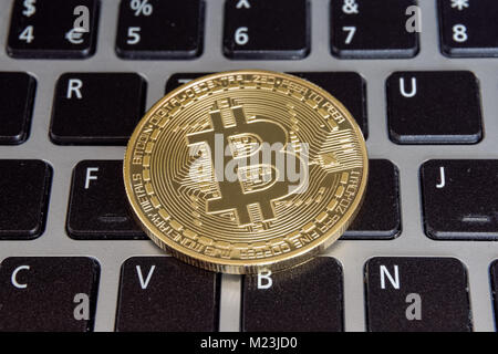 Bitcoin cryptocurrency coin on a computer keyboard Stock Photo