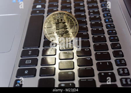 Bitcoin cryptocurrency coin on a computer keyboard Stock Photo