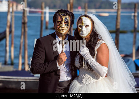 Married couple behind Venetian Wedding Masks, Venice, Italy Stock Photo