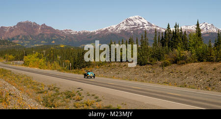 Long panoramic vintage car moves along north Alaska highway North America Stock Photo