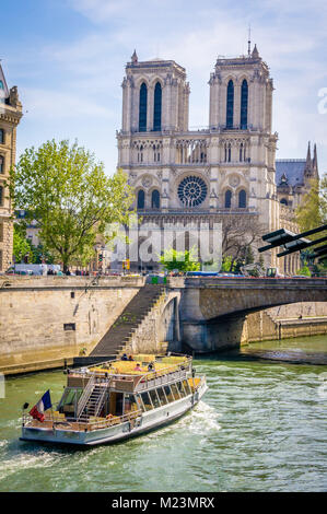 Notre-dame-de-Paris cathedral and a boat passing by on the Seine in Paris Stock Photo