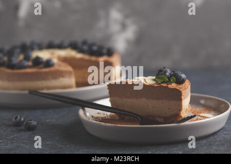 Raw vegan chocolate-caramel cheesecake with blueberries and almonds. Healthy vegan dessert food concept. Stock Photo