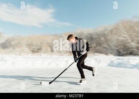 Man playing ice hockey on a frozen lake Stock Photo