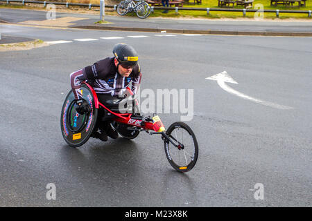 Wheelchair user at Southport, Merseyside. 4th February, 2018.  The seventh Mad Dog 10k race. Wheelchair entrant.; Southport's Mad Dog 10k affirmed its status as one of the town's biggest events with another huge event. Some 2,500 runners took part in the charity run around the coastal resort. Credit; MediaWorldImages/AlamyLiveNews. Stock Photo