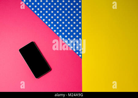 Smart phone lying on colorful background, top view. Stock Photo