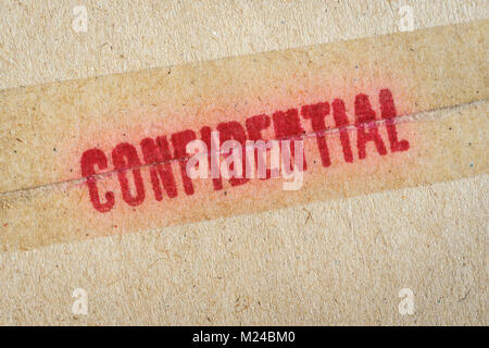 Red 'Confidential' word printed on brown vintage envelope. Stock Photo