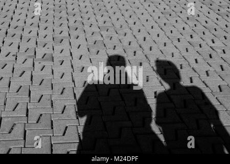 Shadow of man and woman on the paving stone Stock Photo