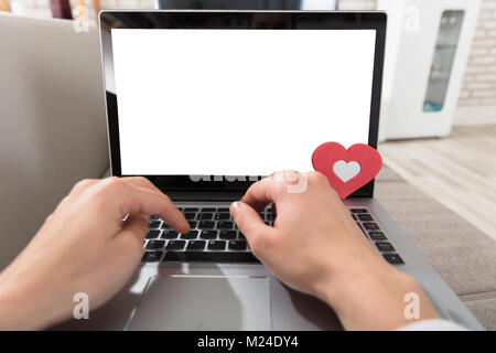 Close-up Of A Person's Hand Typing On Laptop With Blank Screen Stock Photo