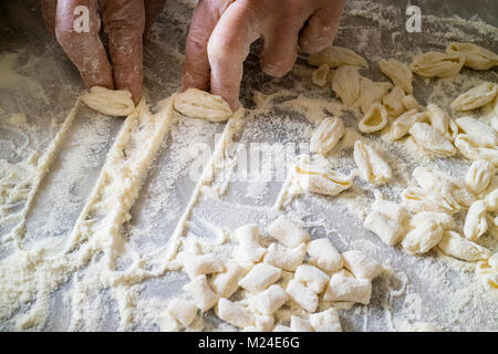 Italian woman making traditional fresh homemade pasta on a marble table Stock Photo