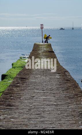 Boy Crabbing from a Coastal Stone Pier Breakwater at Dawlish Beach. Summer 2015 on a Tranquil Day. Devon, UK. Stock Photo