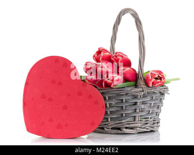 Red tulip flowers bouquet in basket and heart gift box. Valentine's day greeting card. Isolated on white background Stock Photo