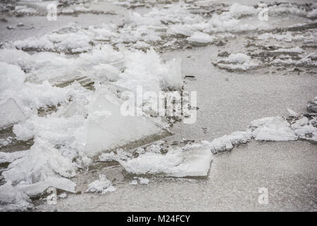 snow covered formed pack ice on the background of winter river water. Ice collision. Stock Photo