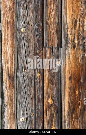 A close-up shot of a rustic wooden texture featuring aged wooden planks. The surface reveals the natural grain patterns, knots, and weathered lines. Stock Photo