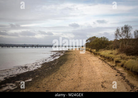 The beach at Hamble-le-Rice with the Oil Terminal Jetty in the distance Stock Photo