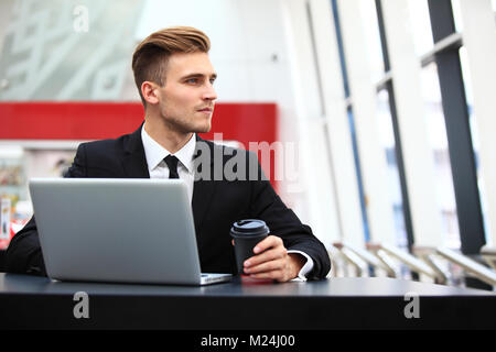 Young adult using laptop in airport lounge Stock Photo