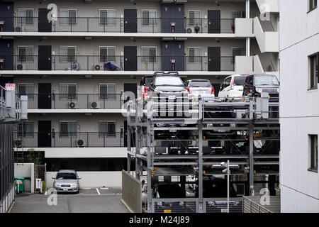 Multi-level vertical lift parking lot three stories high by an apartment building in Kyoto, Japan 2017 Stock Photo