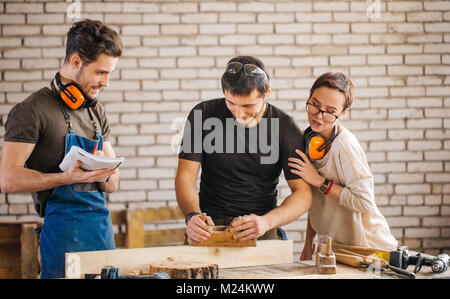 carpenter with students in woodworking workshop Stock Photo