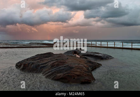 North Curl Curl rockpool photographed during a stormy sunset. Sydney, Northern Beaches, Australia. Stock Photo