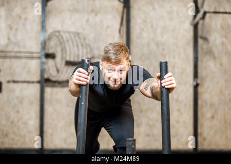 Man pushing sled in the gym Stock Photo