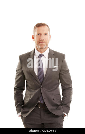 Executive middle aged businessman wearing suit while standing at isolated white background. Stock Photo