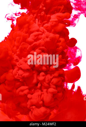 red color paint pouring in water Stock Photo