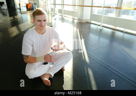 Guy doing drinking water before morning training.  Stock Photo