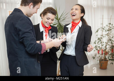 Portrait of three carefree office workers laughing while chatting in modern office Stock Photo