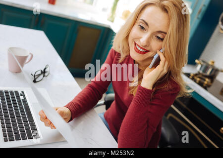 Joyful freelancer talking on the phone Stock Photo