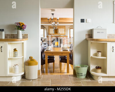 A view through a home from the kitchen, across the living room to a wood burning stove in a brick built hearth Stock Photo