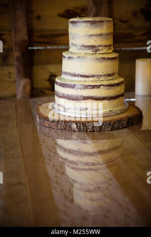 Three tiered celebration cake on wooden table Stock Photo