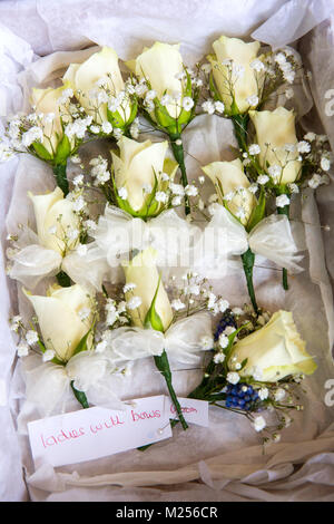 Wedding boutonnieres with handwritten label in tissue paper, overhead view Stock Photo