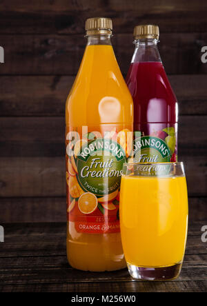 LONDON, UK - FEBRUARY 02, 2018: Bottles and glass of Robinsons Fruit Juices with on wooden background. Stock Photo