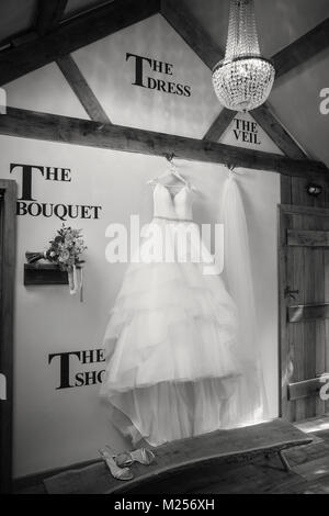 Wedding dress, veil and bridal bouquet in shop display, B&W Stock Photo